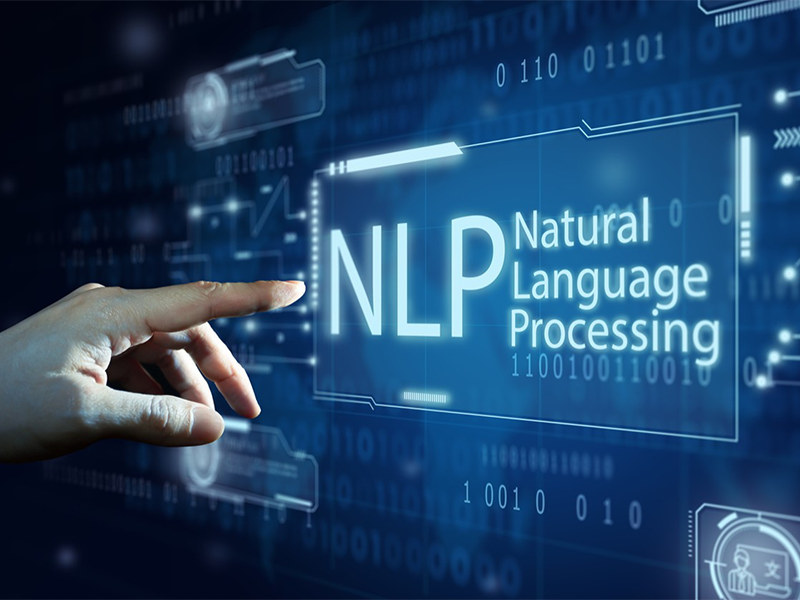 Uma mão branca toca em interface digital com o texto NLP – Natural Language Processing, com código binário abaixo do texto e demais elementos gráficos na imagem.